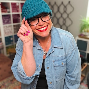 Può includere: Un berretto in maglia color verde acqua con una visiera corta e una trama a coste. Il cappello è realizzato in filato e presenta una calotta arrotondata che aderisce bene. Il design include una visiera anteriore strutturata.