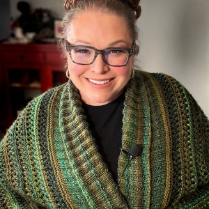 An elegantly draped, hand-knit cocoon cardigan displayed on a Marly Bird, showcasing rich hues of green with a subtle variegated pattern, chunky ribbed collar, and a large decorative button. Marly Bird Know Your Worth Knit Cocoon Cardigan