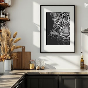 Peut inclure: Une photo en noir et blanc d'un visage de l&eacute;opard, encadr&eacute;e dans un cadre noir. La photo est accroch&eacute;e &agrave; un mur blanc dans un d&eacute;cor de cuisine.