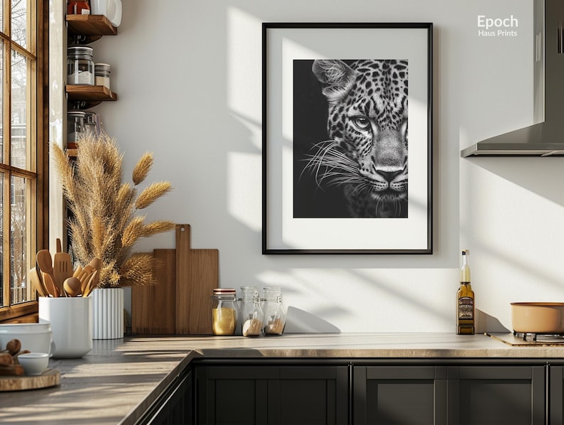 Peut inclure: Une photo en noir et blanc d'un visage de l&eacute;opard, encadr&eacute;e dans un cadre noir. La photo est accroch&eacute;e &agrave; un mur blanc dans un d&eacute;cor de cuisine.