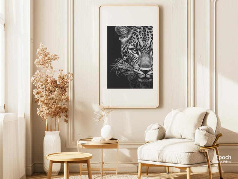 Peut inclure: Photographie en noir et blanc en gros plan d'un visage de l&eacute;opard. Le l&eacute;opard regarde directement la cam&eacute;ra avec une expression s&eacute;rieuse. L'image est imprim&eacute;e sur un fond blanc et encadr&eacute;e dans un simple cadre en bois.