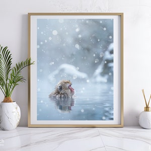May include: A snow monkey relaxes in a hot spring, surrounded by a snowy landscape. The monkey is brown and white with a red face. The water is clear and blue, and the snow is falling softly.