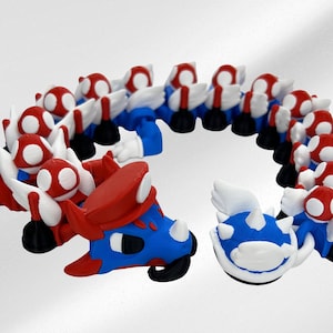 May include: A whimsical, colorful sculpture of a creature with a red mushroom cap head, blue body, and white wings. The sculpture is made of multiple connected pieces, forming a circular shape. The creature has a smiling face.