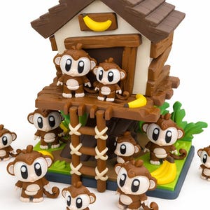 May include: A toy playset featuring a brown treehouse with a banana on the roof and several brown monkey figurines. The monkeys have white faces and are posed around the treehouse and on the base.