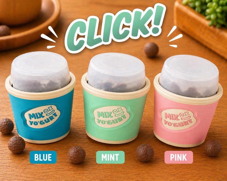 May include: Three colorful yogurt cups, blue, mint, and pink, each with a clear lid and filled with a dark substance. The cups have the text "Mix Ox Yogurt" and are surrounded by chocolate-covered candies. The word "CLICK!" is in the background.