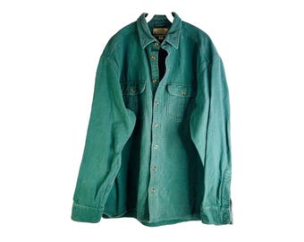 May include: A green long-sleeved button-down shirt with two chest pockets and a button-up collar.