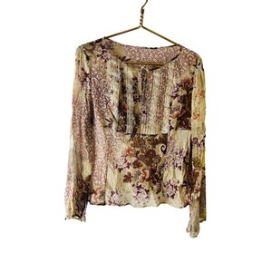 May include: A beige and brown floral print long-sleeved blouse with a lace trim neckline.