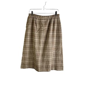 May include: A brown and beige plaid skirt with a straight cut and a high waist.