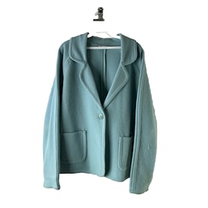 May include: A teal blue blazer with a single button closure and two patch pockets. The blazer has a notched collar and long sleeves.