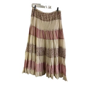 Könnte beinhalten: Ein mehrlagiger Maxirock mit cremefarbenem Hintergrund und rosa und roten Streifen und Blumenmustern.