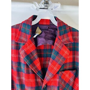 May include: Red and green plaid jacket with a button closure. The jacket has a purple lining and a label that says "U263".