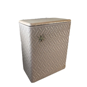 Könnte beinhalten: Ein weißer Wäschekorb aus Weide mit einem sternförmigen Griff. Der Korb hat ein Rautenmuster und einen Deckel.