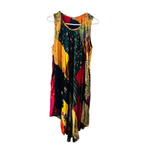 May include: A sleeveless dress with a patchwork design featuring various colours and patterns, including yellow, red, green, and black.