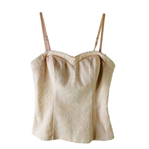 May include: A pale peach-colored, strapless, lace top with a sweetheart neckline and adjustable straps.