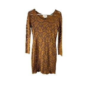May include: A brown lace dress with long sleeves and a scoop neck. The dress has a floral pattern.