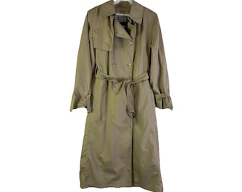 Puede incluir: Un abrigo tipo gabardina de color beige con diseño cruzado, cinturón y cuello clásico. El abrigo está colgado de una percha blanca sobre un fondo blanco. El abrigo tiene un estampado de cuadros en el interior del cuello.