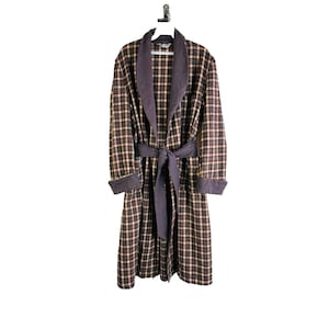 May include: A brown and tan plaid robe with a dark brown collar and sash. The robe has a long, flowing design and is perfect for lounging around the house.