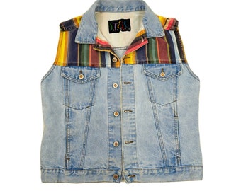 May include: A light blue denim vest with a colorful striped fabric panel across the shoulders and a small label that reads "ST.E.L.S."