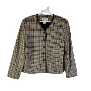 Puede incluir: Blazer Pendleton con estampado de cuadros en tonos beige, rojo y negro. El blazer tiene un ribete de cuero negro alrededor del cuello y una botonadura frontal. La etiqueta es visible en la parte superior de la espalda.