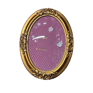 Puede incluir: Marco de fotos ovalado dorado con detalles ornamentados. El marco rodea un fondo rosa con lunares blancos y pegatinas decorativas. Un diseño clásico, adecuado para exhibir fotos u obras de arte.