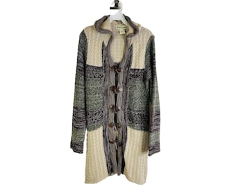 May include: A long, hooded cardigan sweater with a toggle closure. The sweater is made of a soft, knitted fabric and features a patchwork design in shades of beige, green, and purple.