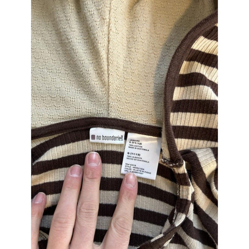 Op de afbeelding: Bruin en beige gestreept hooded shirt met een "no boundaries" label. Het label zegt "Juniors L (11/13) 100% Katoen Gemaakt in Guatemala RN# 83019"