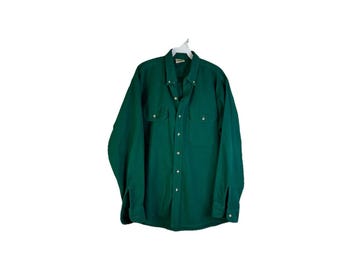 May include: A dark green long-sleeved button-down shirt with two chest pockets.