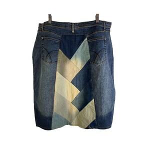 Peut inclure: Une jupe en jean avec un motif patchwork. La jupe est faite de différentes nuances de jean bleu et a un motif patchwork bleu clair et beige au dos.