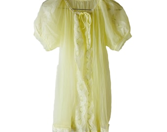 May include: A pale yellow sheer nightgown with lace trim and a tie at the neck.