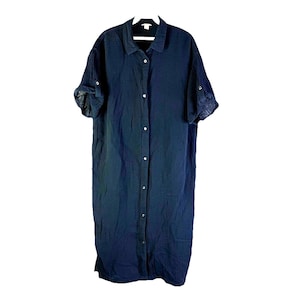May include: A long, navy blue button-down dress with short sleeves. The dress has a collared neckline and buttons down the front. The sleeves are rolled up and secured with a button. The fabric appears to be a lightweight, textured material.