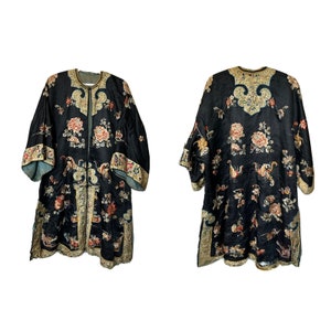 May include: A black silk robe with gold and colorful floral embroidery. The robe has a mandarin collar and long sleeves.