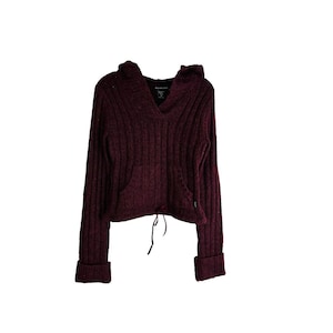 May include: A burgundy hooded sweater with a ribbed knit texture and a drawstring at the bottom.