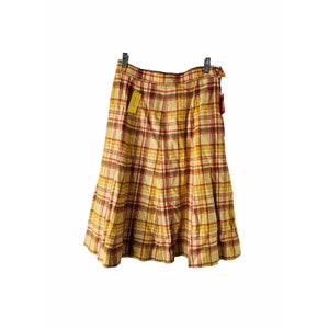 May include: A brown, yellow and red plaid skirt with a pleated design. The skirt has a high waist and a flared silhouette.