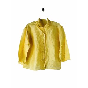 May include: A yellow button-up shirt with long sleeves. The shirt is made of a lightweight fabric and has a relaxed fit.