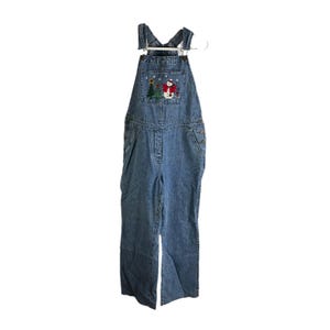 Op de afbeelding: Blauwe denim overall met een sneeuwpop en kerstboom geborduurd op de voorzak.