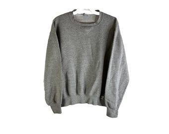 May include: A gray sweatshirt with a crew neck and long sleeves.