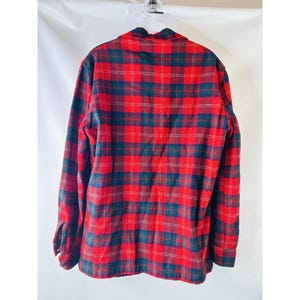 May include: Red and black plaid flannel shirt with long sleeves and a button-up front.