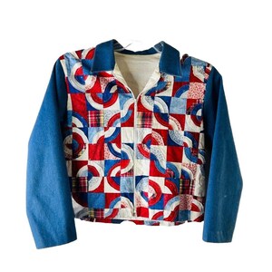 May include: A vintage quilted jacket with a zip closure. The jacket has a patchwork design with red, white and blue fabric squares. The sleeves are a solid blue denim.