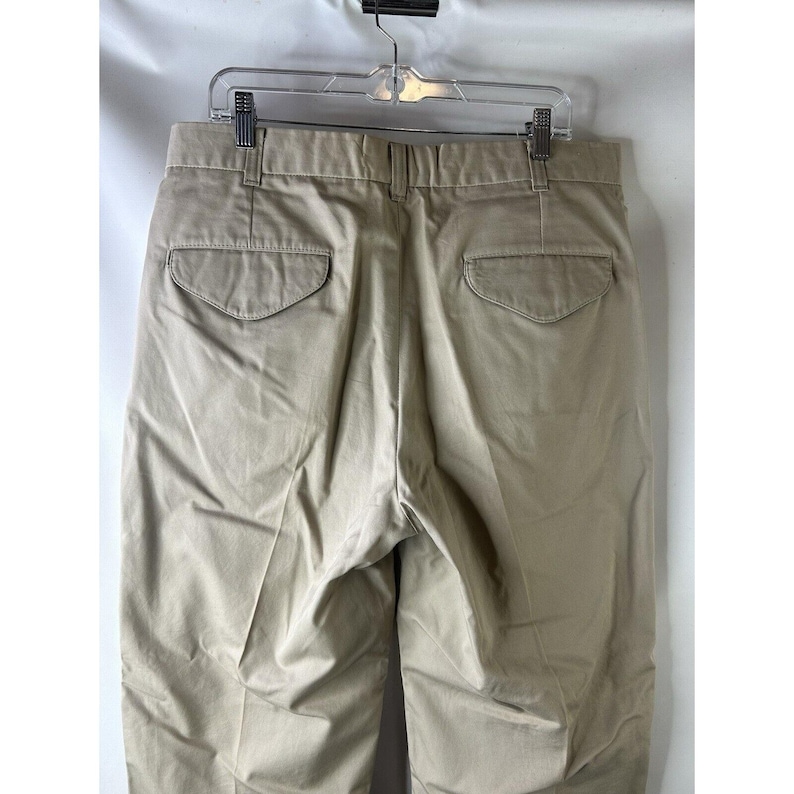 May include: A pair of beige cotton twill trousers with two back pockets.