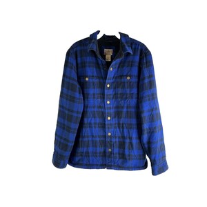 May include: Blue and black plaid flannel shirt with a button-down front. The shirt has a collared neckline and two chest pockets. The shirt is made of a thick, warm material, perfect for cooler weather.