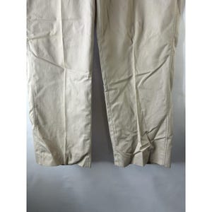 May include: A pair of beige casual trousers. The trousers are made of a lightweight fabric and have a straight leg.