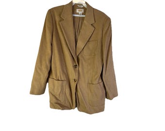 Könnte beinhalten: Ein beigefarbener Blazer mit fallendem Revers, zwei Vordertaschen und einem Ein-Knopf-Verschluss. Der Blazer hängt an einem weißen Kleiderbügel vor weißem Hintergrund. Der Blazer hat ein klassisches, maßgeschneidertes Design.