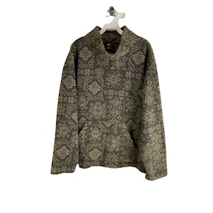 May include: A brown and green patterned fleece pullover with a half-zip closure and a kangaroo pocket. The pullover has a high neck and long sleeves.