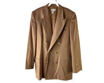 Könnte beinhalten: Ein brauner zweireihiger Blazer mit goldenen Knöpfen. Der Blazer hat einen klassischen Stil und ist aus glattem Stoff gefertigt.