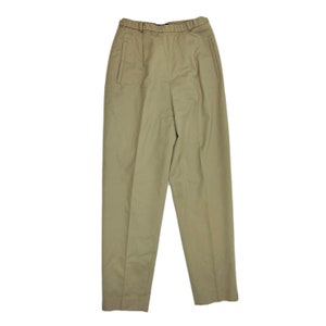 Puede incluir: Un pantalón de color caqui de pierna recta y delantero plano. El pantalón tiene una cintura con trabillas y dos bolsillos delanteros.