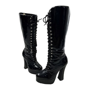 May include: A pair of black patent leather platform boots with lace-up fronts and chunky heels.
