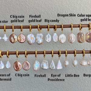 May include: A collection of gold hoop earrings with various white and pink iridescent pearl charms, labeled with names like Cross star, C big coin gold leaf, Fireball gold leaf, Big candy, Dragon Skin, Color square gold leaf, Tears of Mermaid, and Burger.