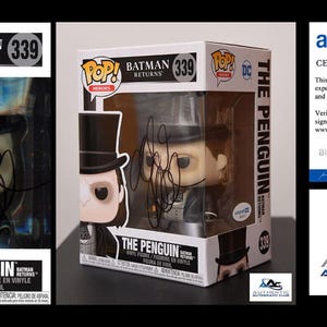 Może przedstawiać: Figurka Funko Pop! Heroes Pingwina z Batman Returns, numer 339, w oryginalnym pudełku. Pudełko i figurka są podpisane. Zawiera certyfikat autentyczności od AutographCOA.