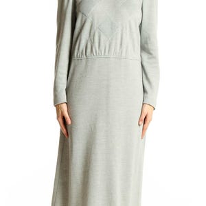 May include: A light gray dress with long sleeves and a round neckline. The bodice features a diamond-patterned design. The dress has a fitted waist and a knee-length skirt, suitable for casual or semi-formal wear.