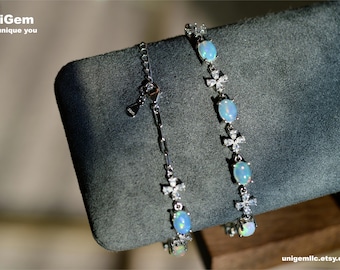 May include: Two silver bracelets with opal stones and flower accents. The bracelets are on a gray background. UniGem For unique you. unigemllc.etsy.com